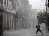 Человек стоит под дождем, вызванным тропическим штормом Паула, ...