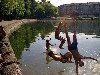 дети прыгают в городское озеро.