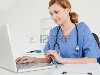 Симпатичная женщина-врач работает на своем ноутбуке в ее операции Фото со ...