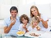 Веселые дети едят пиццу с родителями Фото со стока - 10107746