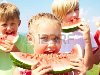 Дети едят красные арбузы на фоне голубого неба Фото со стока - 10430563