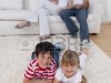 Счастливые дети смотрят телевизор на полу в гостиной Фото со стока - ...