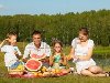Открытый Портрет группы счастливых семей, имеющих пикник на зеленой траве в ...